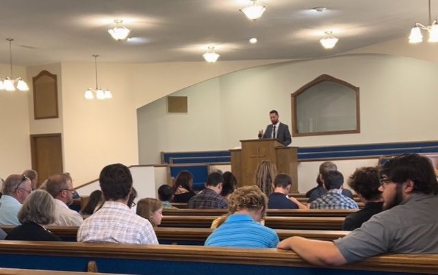 The congregation of Emmanuel Baptist Church, families together in the pews, listening to the sermon